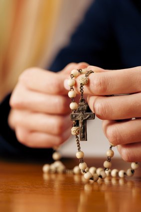 Woman praying with rosary to God