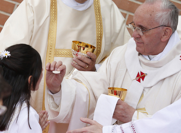 Pope gives first Communion to girl during Mass at Sts. Elizabeth and Zechariah Parish on outskirts of Rome