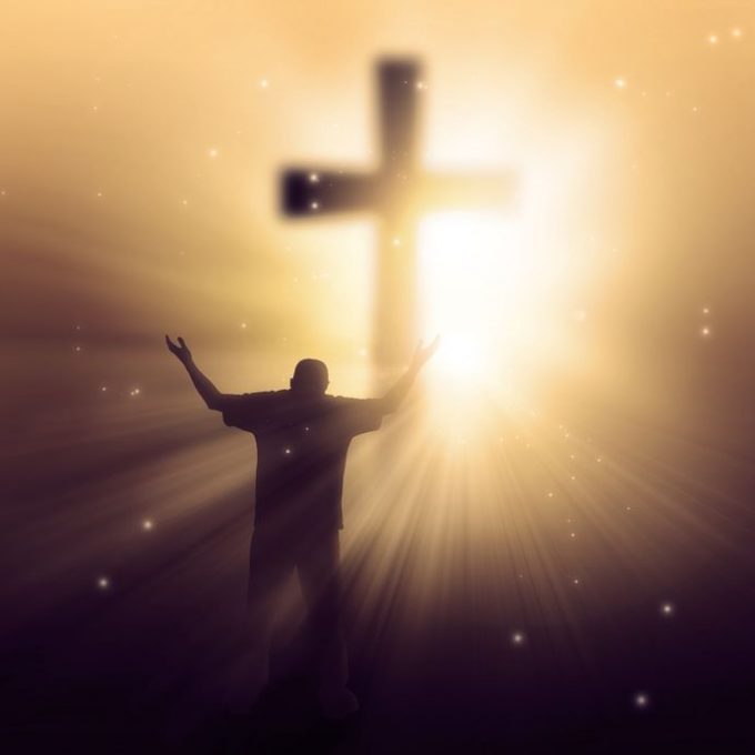18839055 – a man walking towards a cross with sunbeams