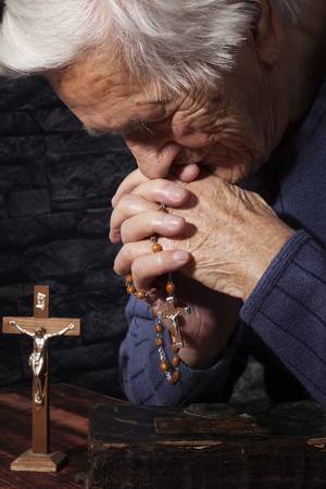 54035444-old-wrinkled-beautiful-woman-praying-with-rosary-