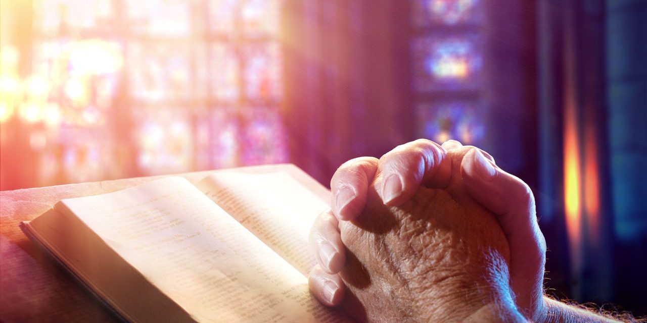 1280-512727662-man-praying-with-bible