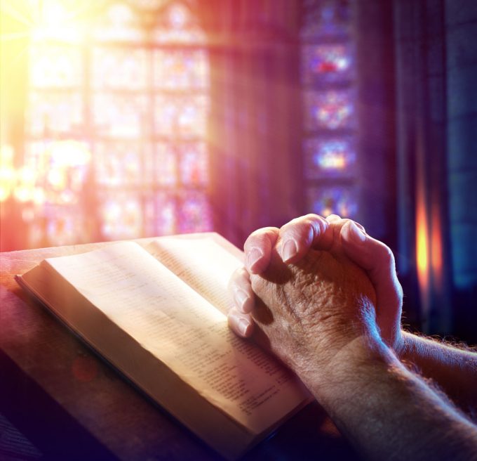1280-512727662-man-praying-with-bible