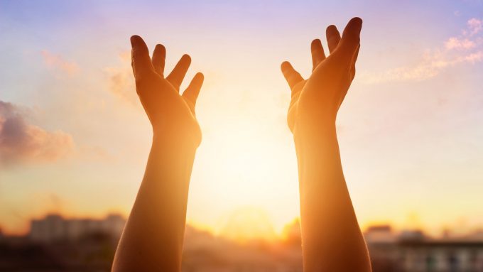 Respect and pray on the sunset in city background