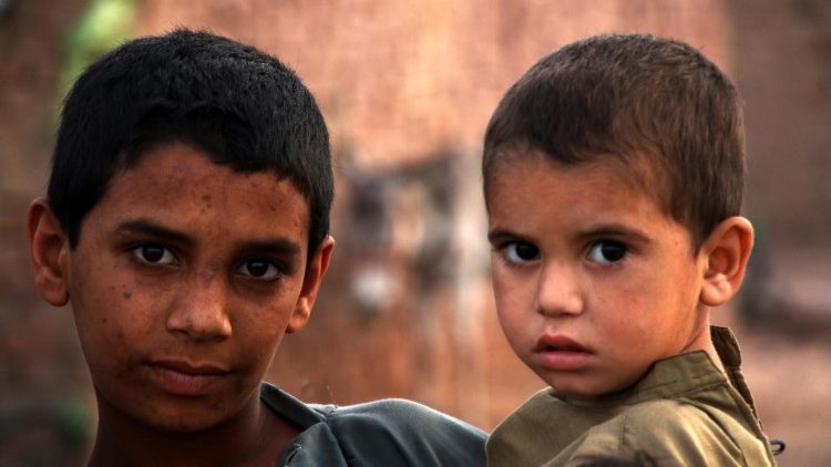 criancas-afegas-refugiadas Dois meninos afegãos olhando para a câmera; um é mais velho e o outro mais novo.