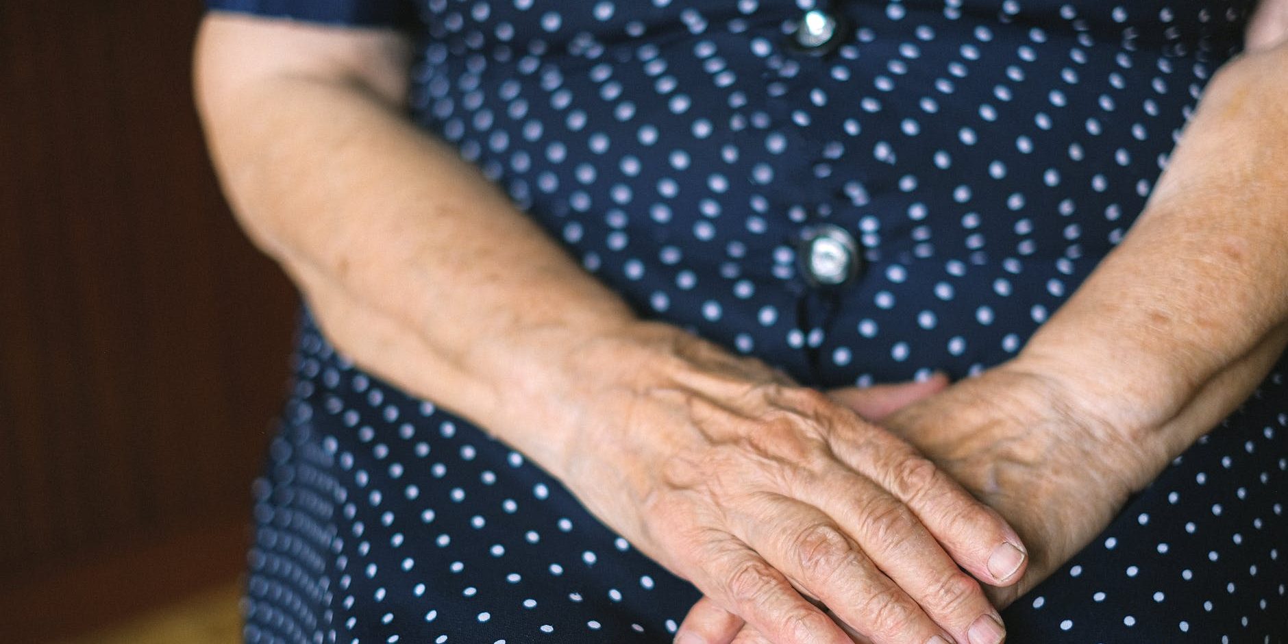 Mãos cruzadas de mulher idosa.