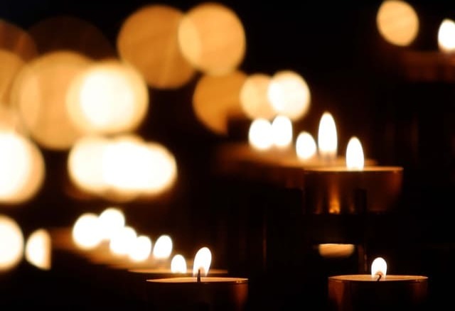 igreja-credo Diversas velas acesas em meio à escuridão.