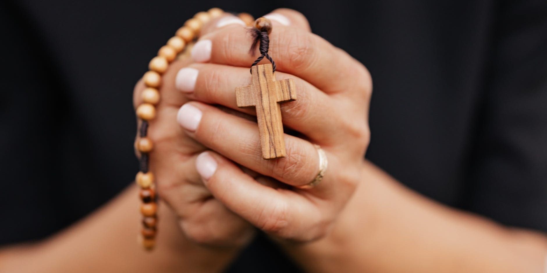 oracao-missao-paz-mocambique Mãos juntas em oração e segurando um terço de madeira.