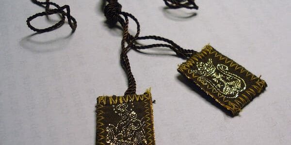 escapulario Escapulário sobre superfície plana e branca.