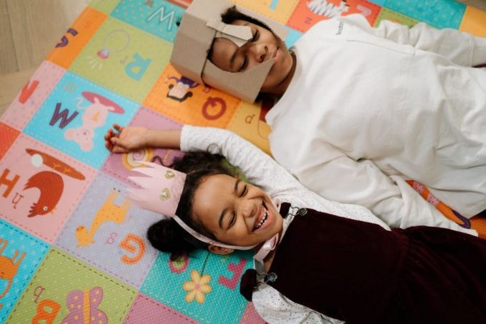 irmaos Menino e menina deitados em tapete colorido.