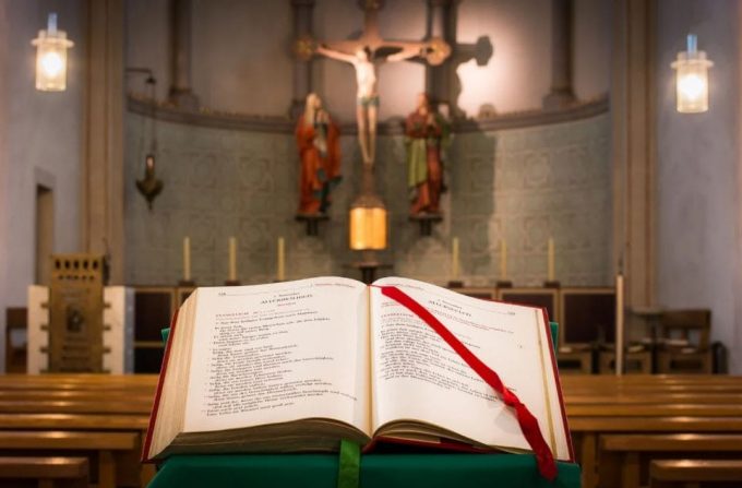 Bíblia aberta em frente a um altar e Jesus crucificado em desfoque.