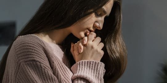 Vista lateral de mulher de cabelos compridos orando