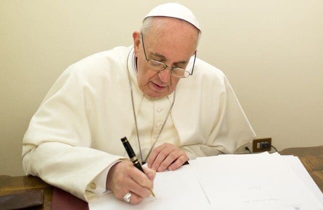 papa-muticom Papa Francisco assinando um documento.