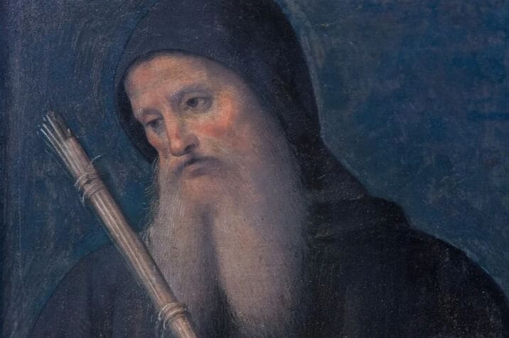 sao-bento (1) Ilustração de São Bento de barba longa e branca; ele usa um capuz preto sobre a cabeça.