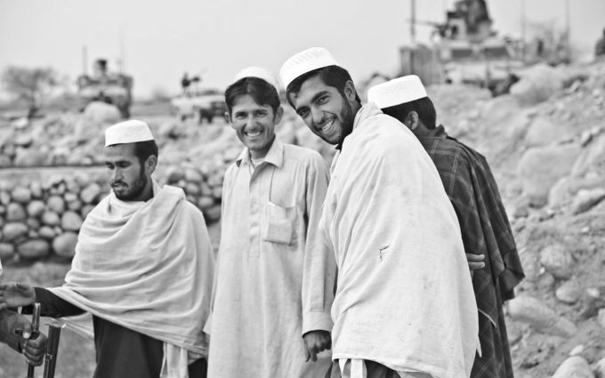 Foto preta e branca de 4 homens afegãos.