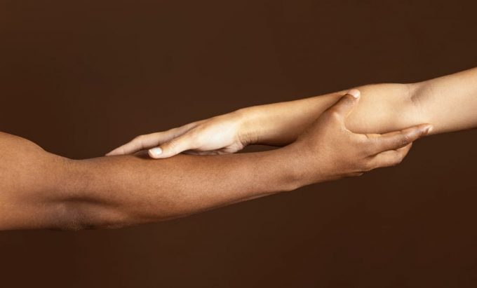 Duas pessoas dando as mãos