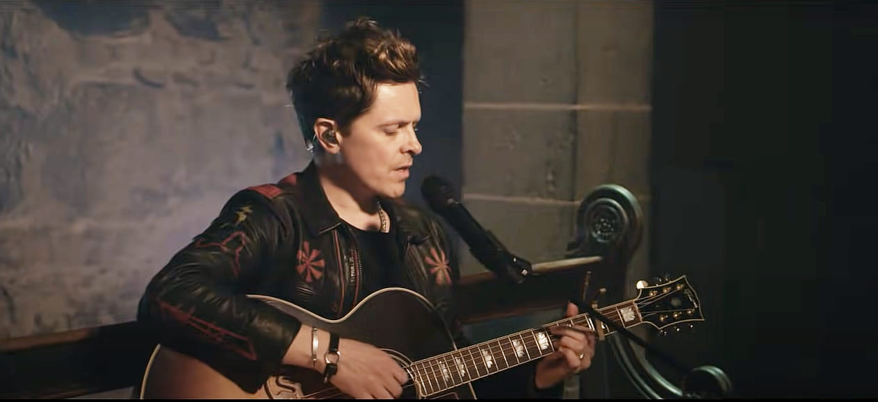 Michael Patrick Kelly com violão e microfone