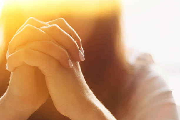 Cute beautiful girl folded her hands in prayer. A woman asks God for help.