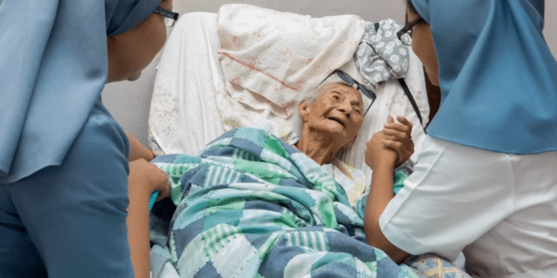 caridade (1) Duas irmãs religiosas amparando idosa em cama de hospital
