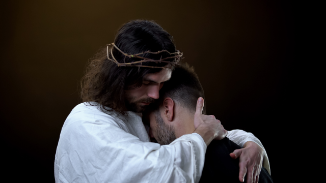 Salvador-en-corona-de-tronos-abrazando-a-hombres-desesperados-paz-religiosa-perdon-shutterstock_1492463657